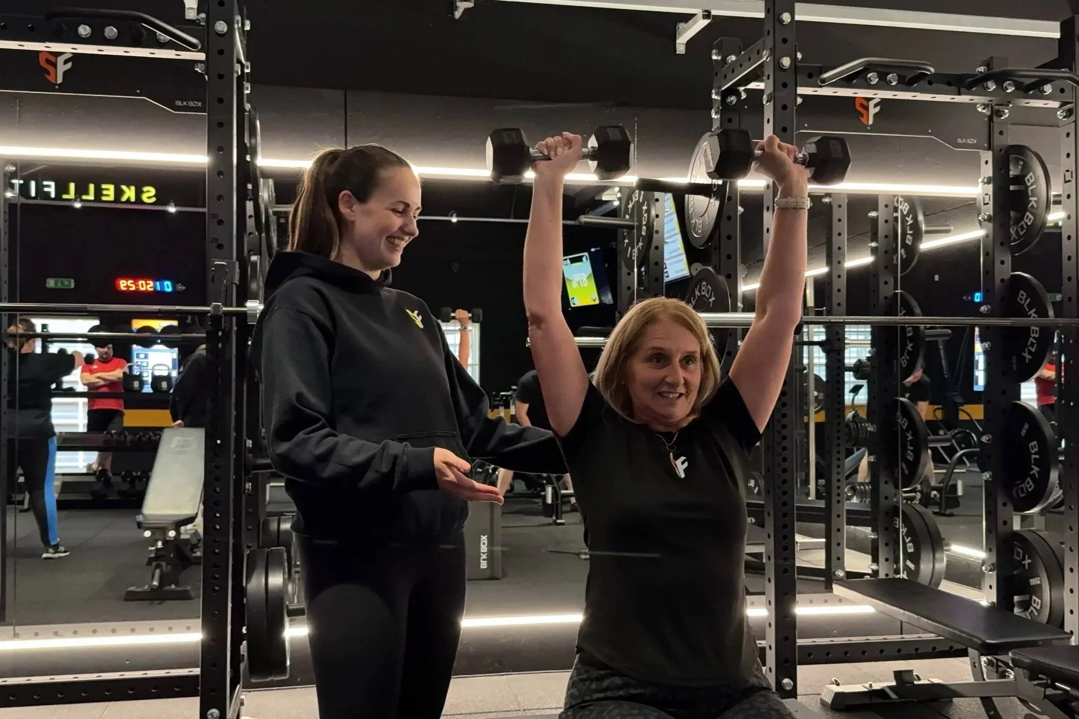 Coach and client lifting weights